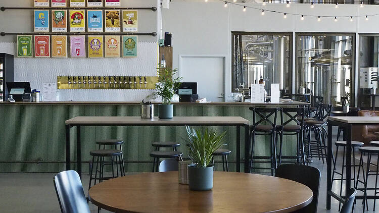 Varikko Panimon sisätila Oulussa, baaritiski hanajuomineen ja asiakaspöytiä.