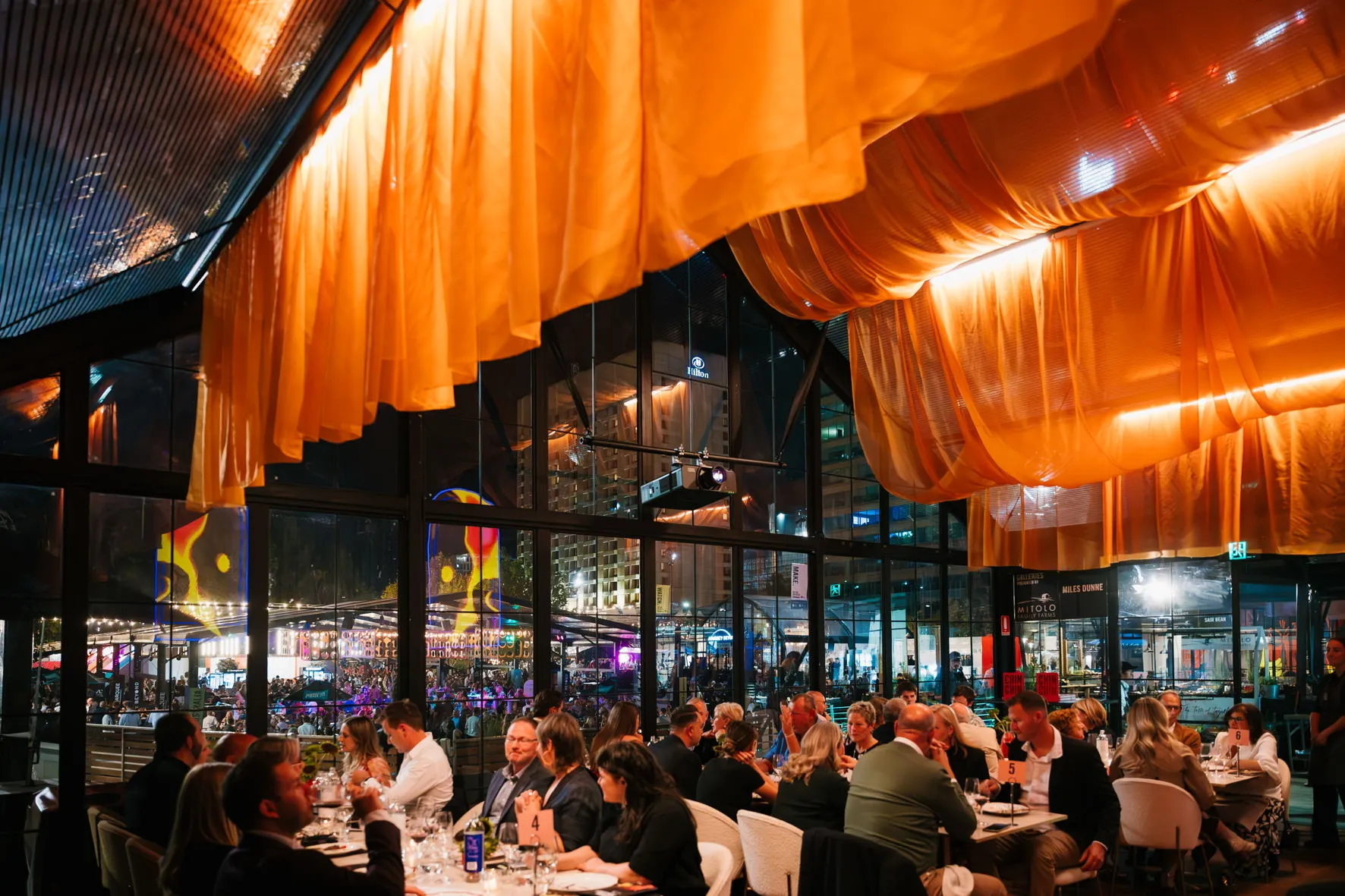 Dining room with orange fabric hanging from ceiling 