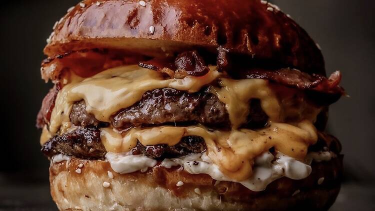 Close up side profile of a Burger & Beyond double cheeseburger