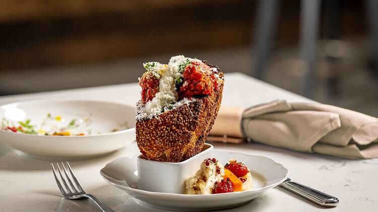 A meatball sandwich sticking out of a small ceramic cup