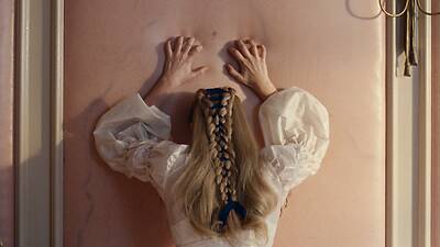 Margot Robbie raapii seinää joka näyttää iholta elokuvassa Humiseva harju Margot Robbie raapii seinää joka näyttää iholta elokuvassa Humiseva harju