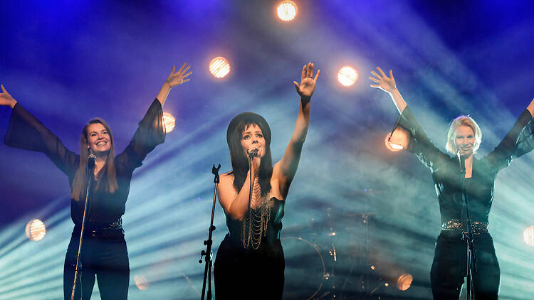 Oona Airola laulaa lavalla Kaija Koon roolissa vierellään taustalaulajat elokuvassa Kaunis, rietas, onnellinen