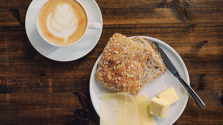 Ylhäältä päin kuvattu Bageri Å:n aamiainen Turussa: kahvia ja hapanjuurileipää juuston ja voin kera.