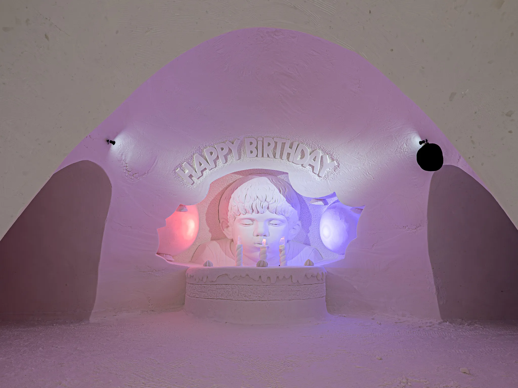 Snow sculpture of a boy blowing birthday candles