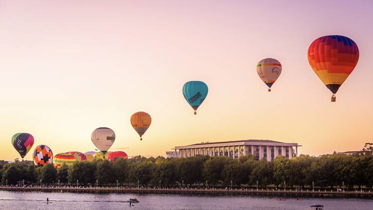 Hot air balloons over lake