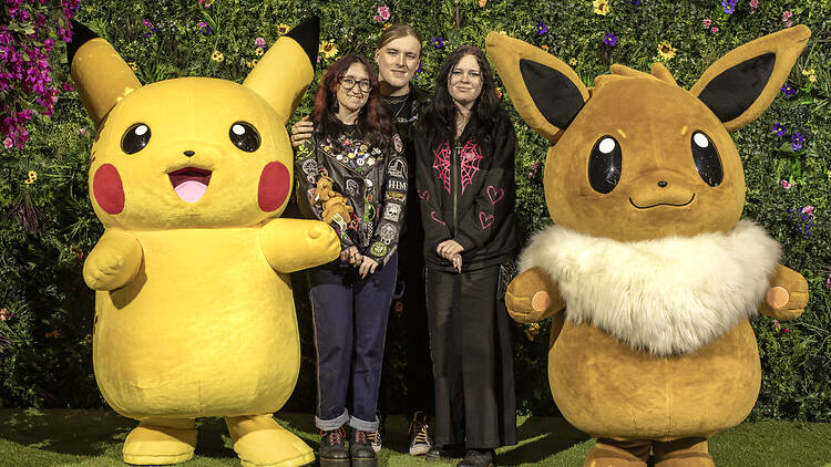 People having their photo taken with a giant Pikachu and Evee at the Pokemon Championships in London