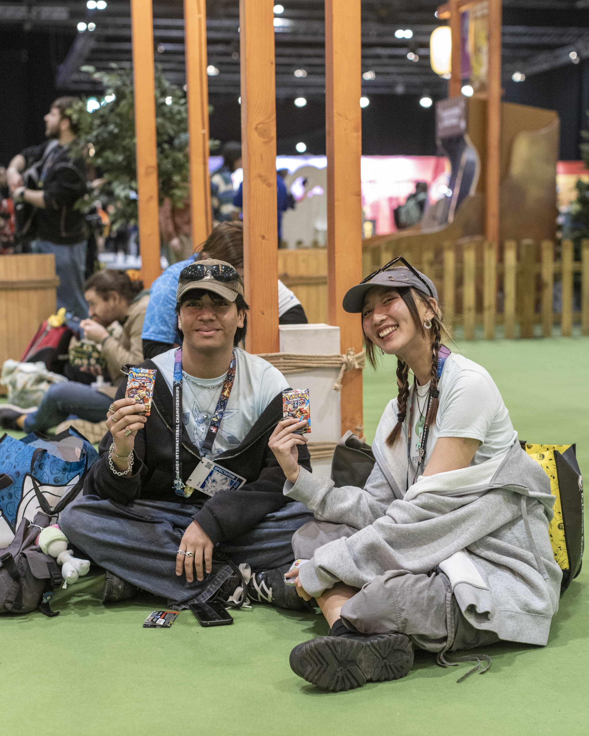 Two friends holding up Pokemon cards 