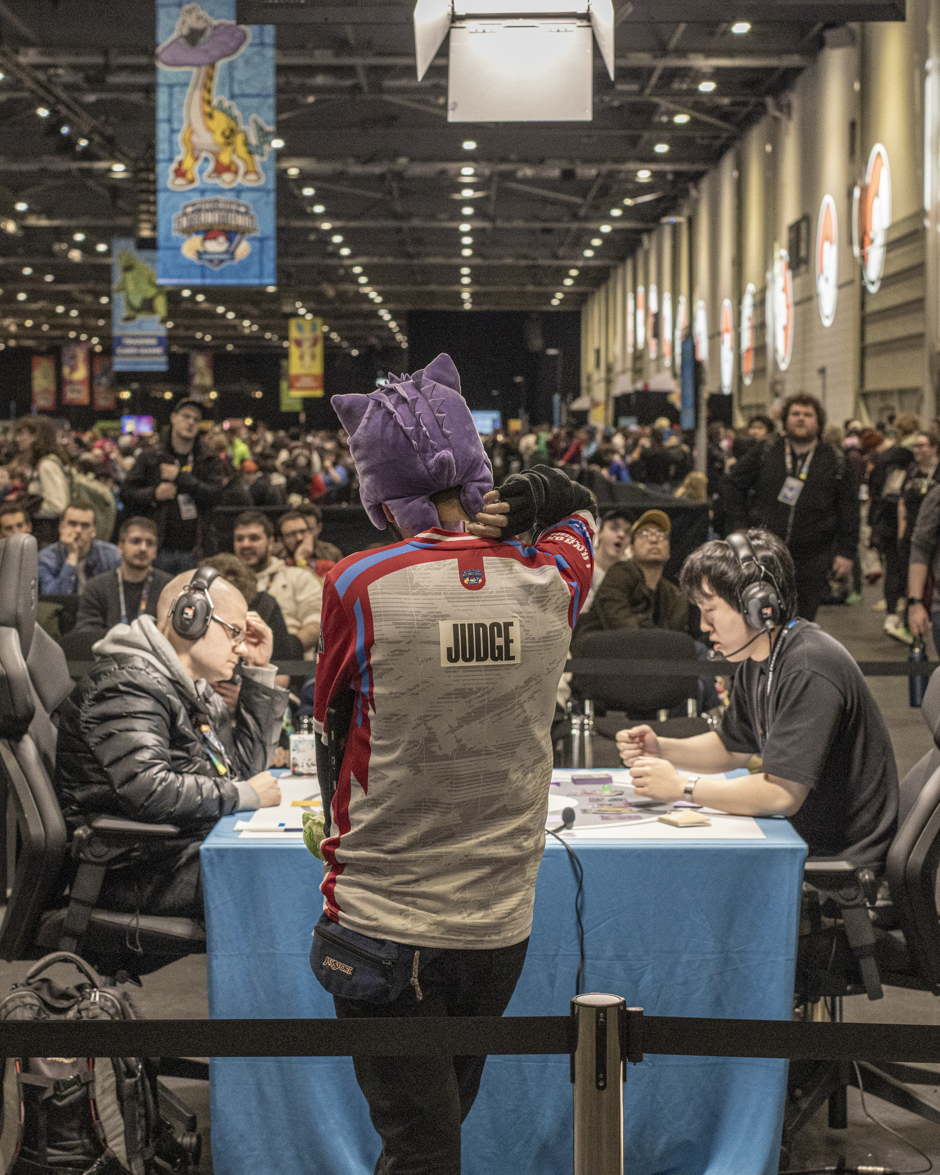 Pokemon players and a judge wearing a purple hat 