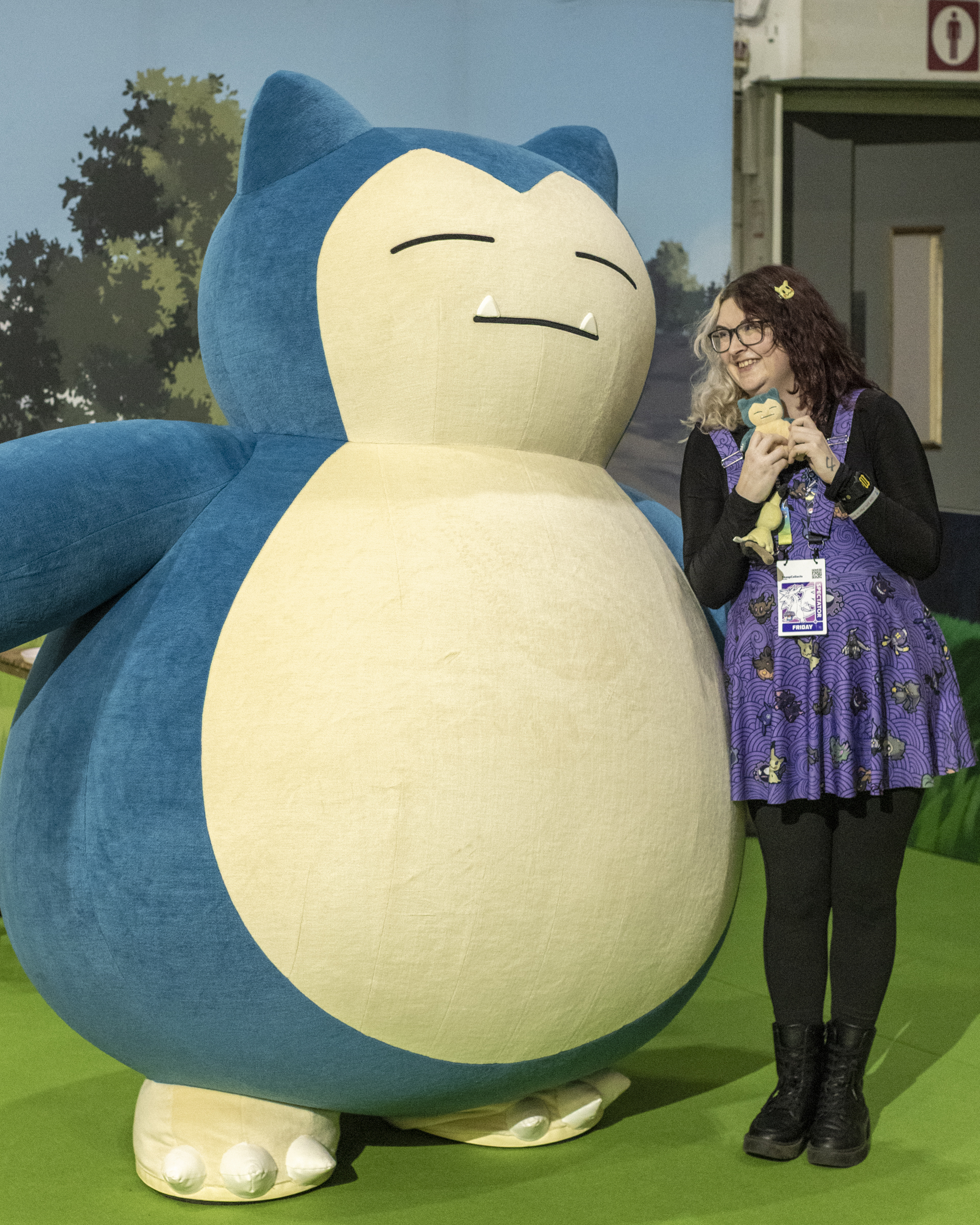 A Pokemon fan posing with a giant Snorlax