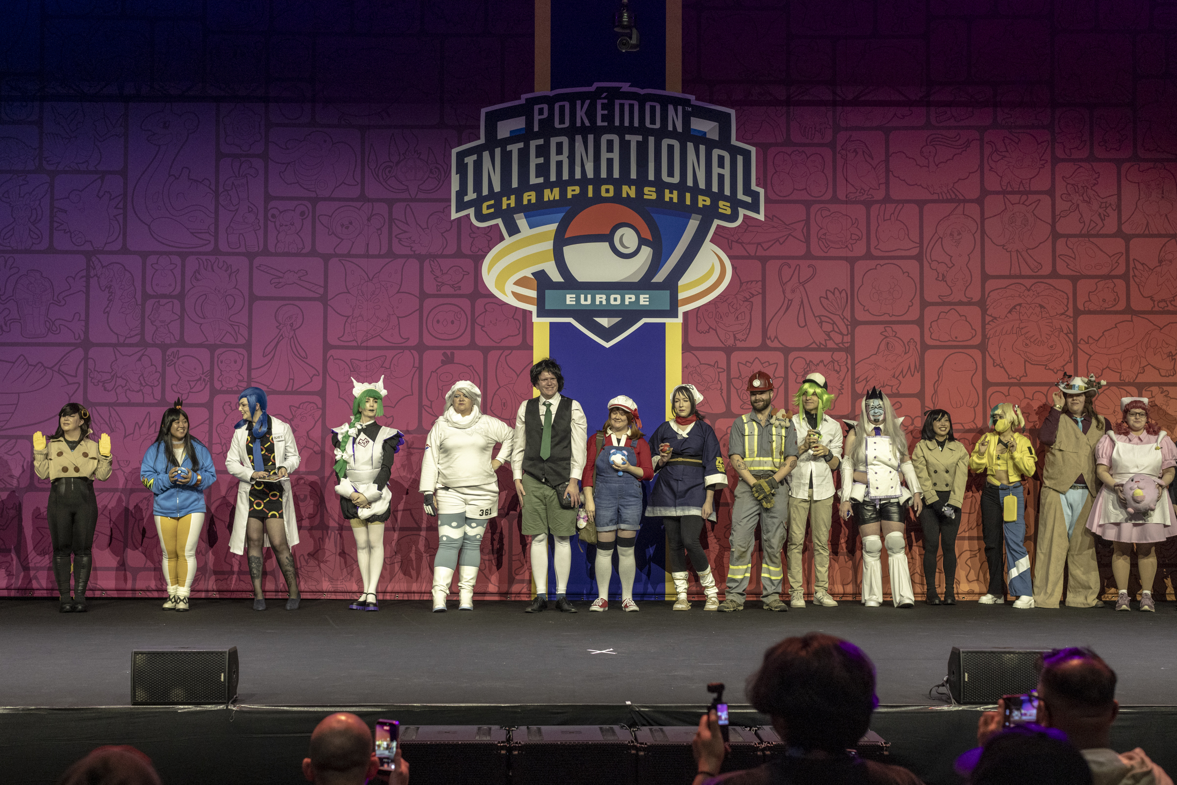 People in different costumes lined up on stage at the Pokemon Championships