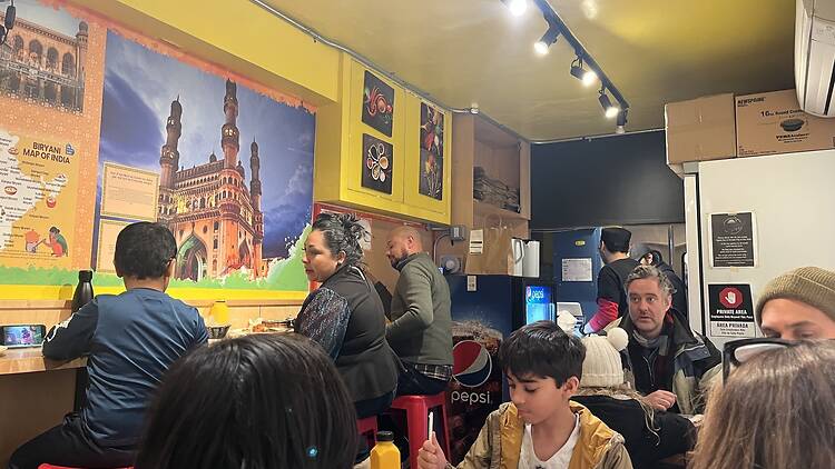 Yellow inside of Hyderabadi Zaiqa with pictures of India on the walls