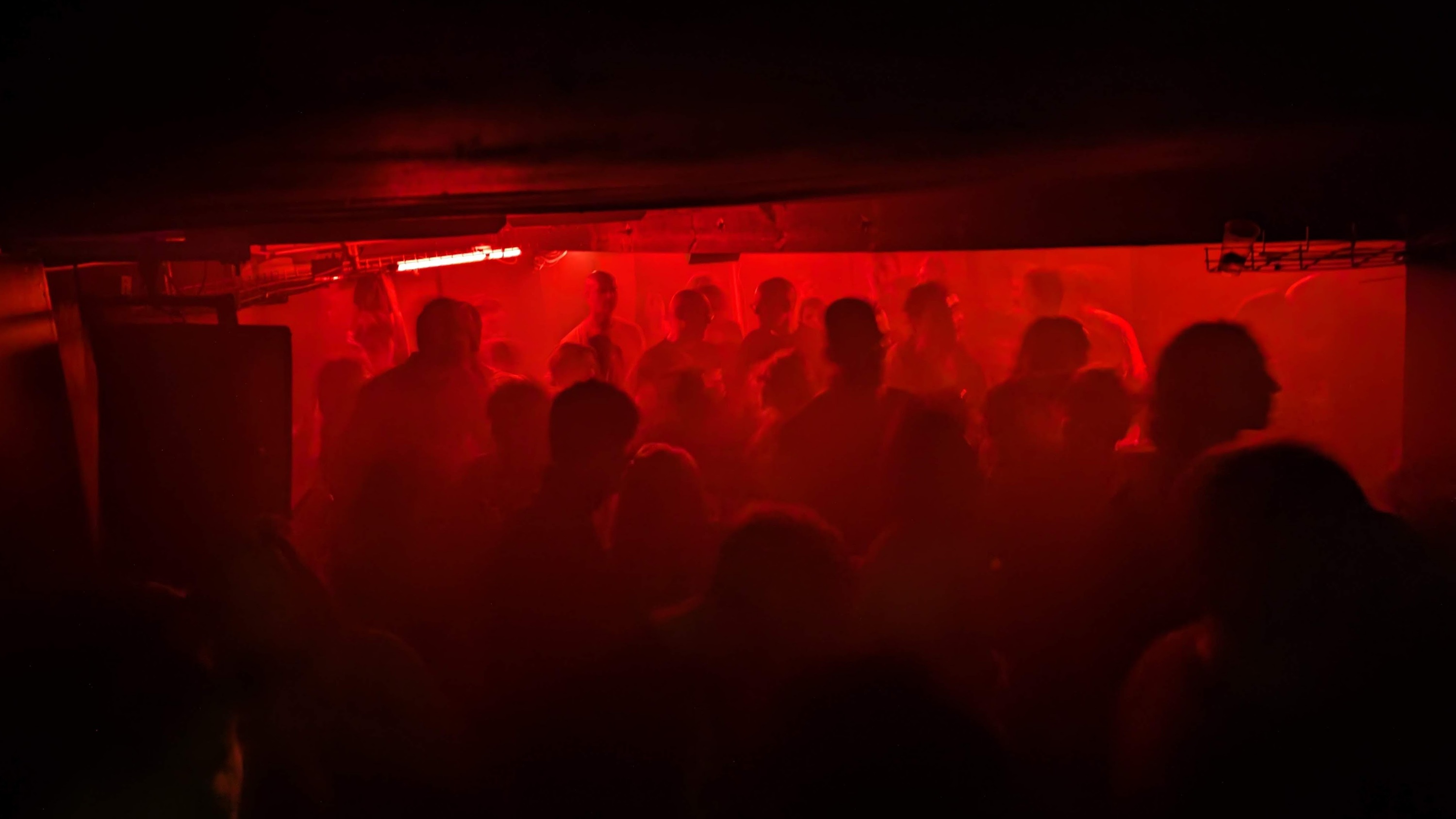 The Glove That Fits, a small dancefloor with low ceilings and dim red lighting 