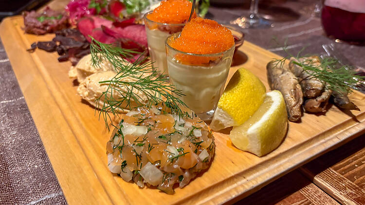 Kalaa, mätiä ja muita annoksia puisella alkupalalautasella Lappi ravintolassa Helsingissä