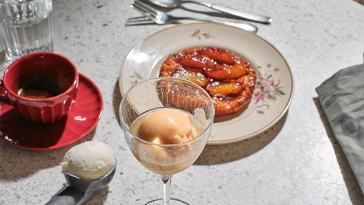 Omenapiirakka lautasella ja jäätelöä lasissa ravintolassa Nolita