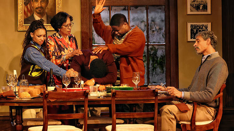 A family around a table, dealing with what looks like family drama