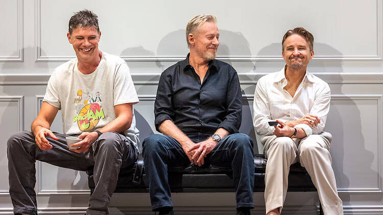 Three male actors sitting in a row