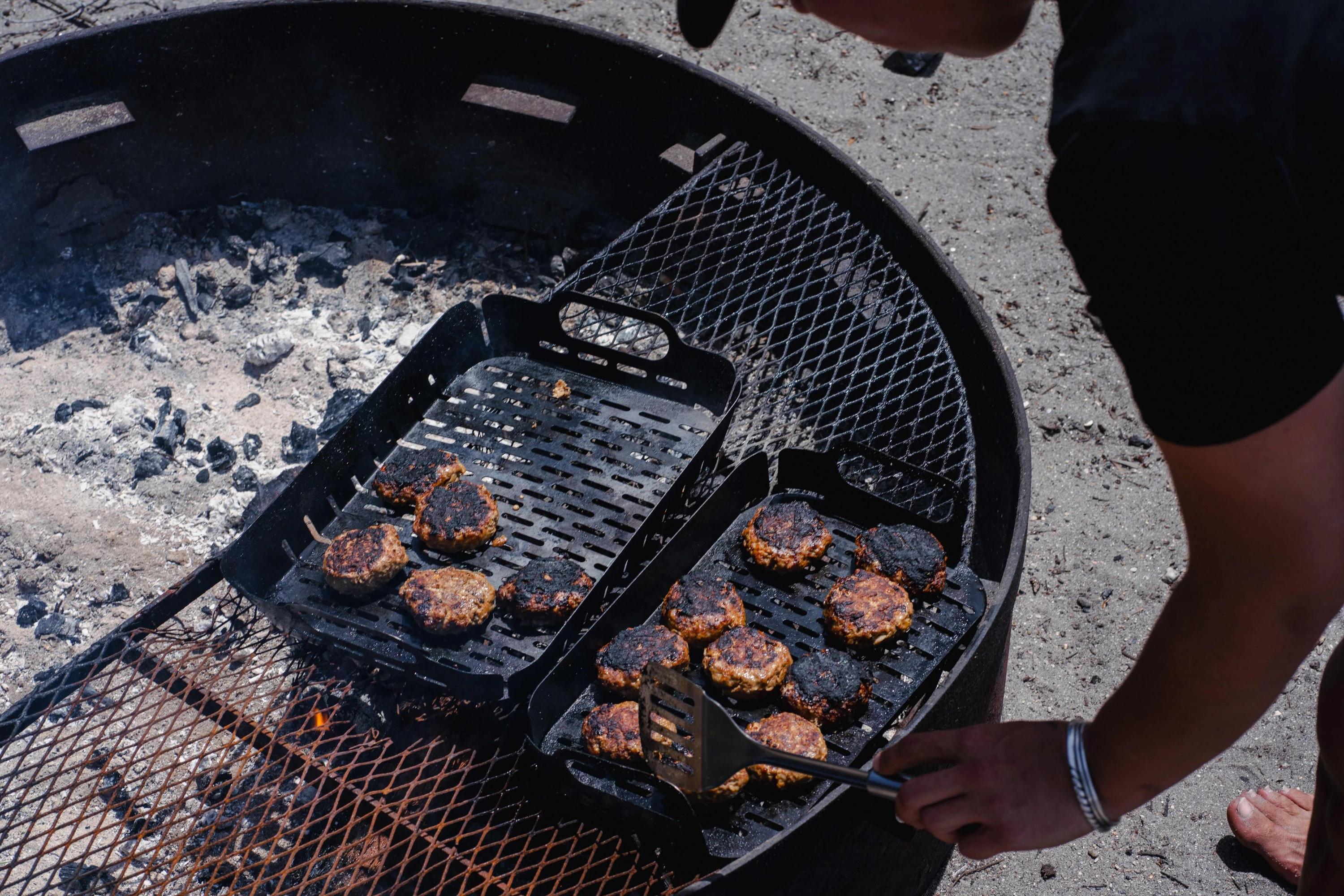 Burger patties cooking over fire