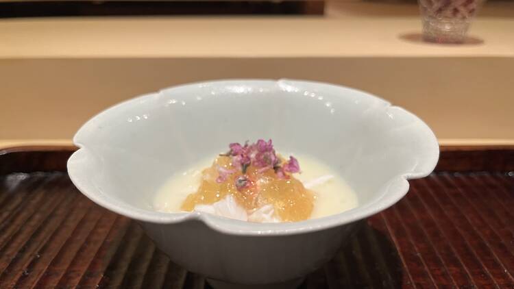 A bowl of soup with yellow jelly on the top