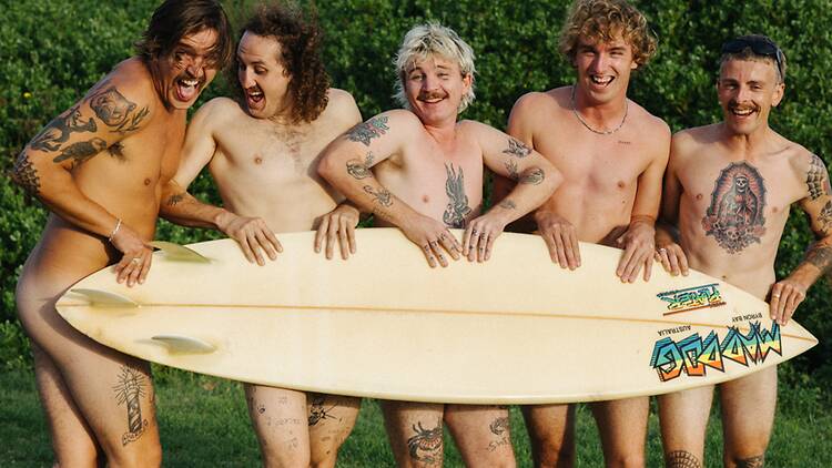 The Terrys Performers of the band The Terrys appear nude behind a surfboard