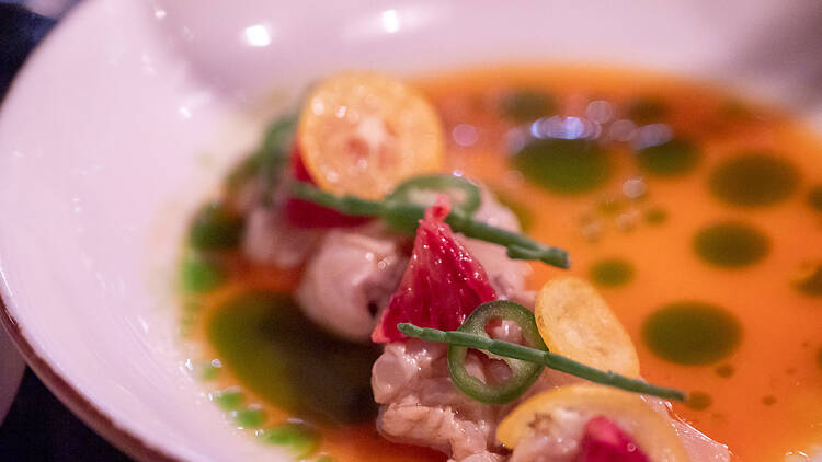 Lautasella siika cevicheä keltaisessa tyrnimarja kastikkeessa jossa vihreitä täpliä