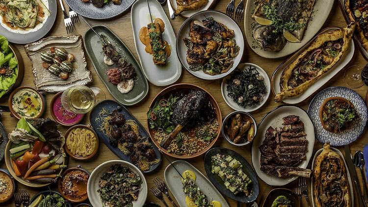 A table full of skewers and legs of lamb