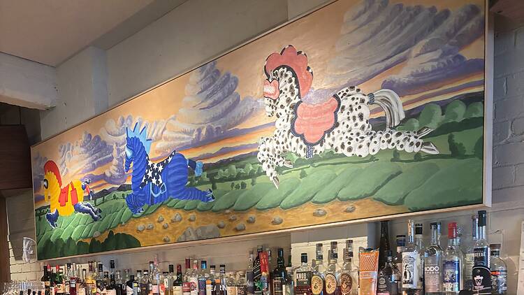 A colourful mural above the bar of Three Horses.