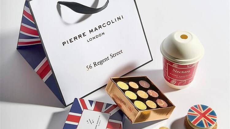 a box of chocolates, cup of hot chocolate and cake with a Union Jack