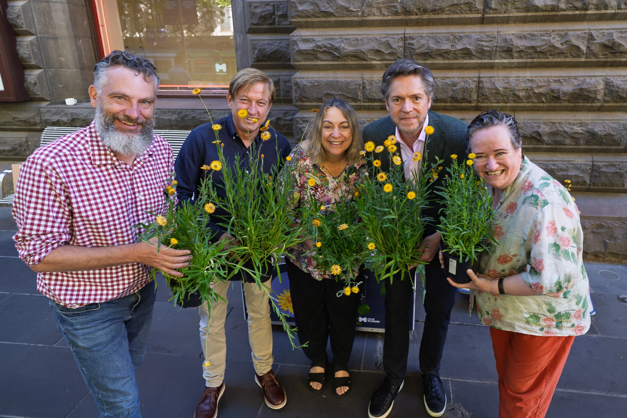 Five people holding the swamp everlasting flower.