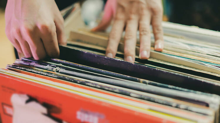 Person sifting through a crate of vinyl records