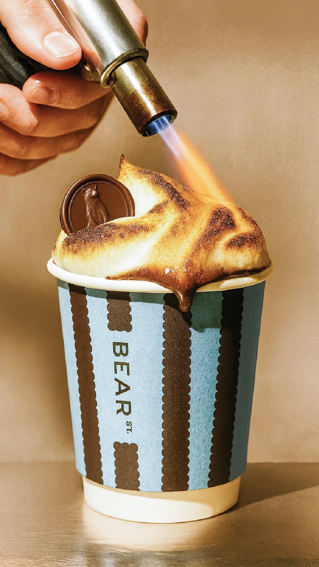 Blowtorch heating marshmallow on a hot chocolate