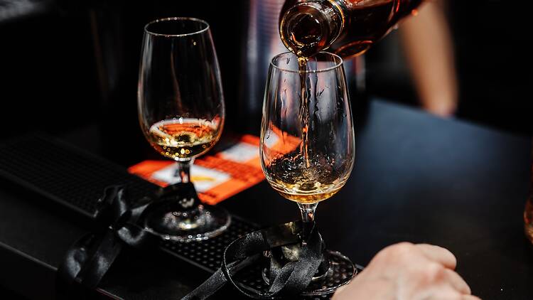 Bartender pours whiskey for tasting. High quality photo