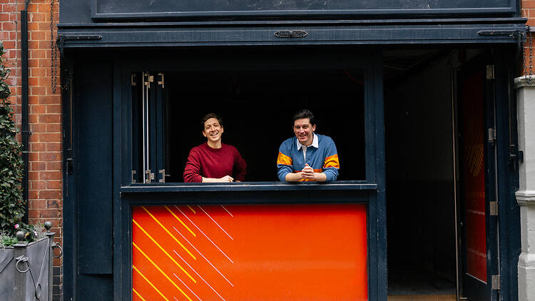 Brutes of Mayfair founders stand at the window of the soon-to-open site
