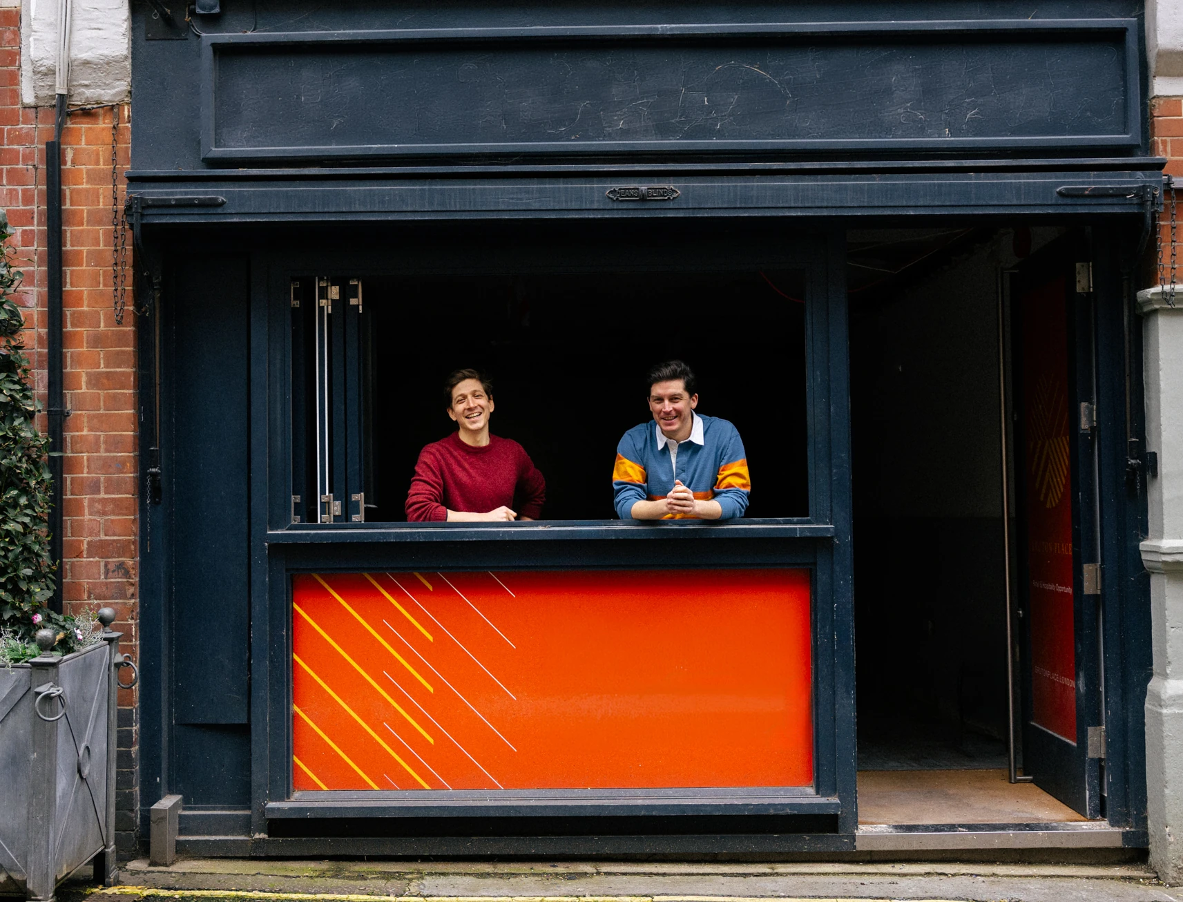 Brutes of Mayfair founders stand at the window of the soon-to-open site