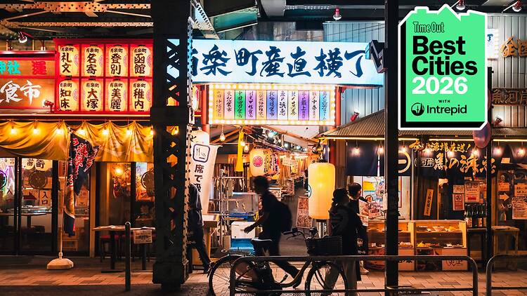 A Tokyo street at night with a badge in the corner of the image reading 'Best Cities 2026 with Intrepid'