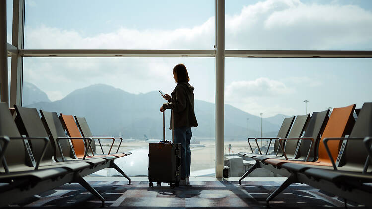Airport Asian woman in airport lounge waiting for flight aircraft