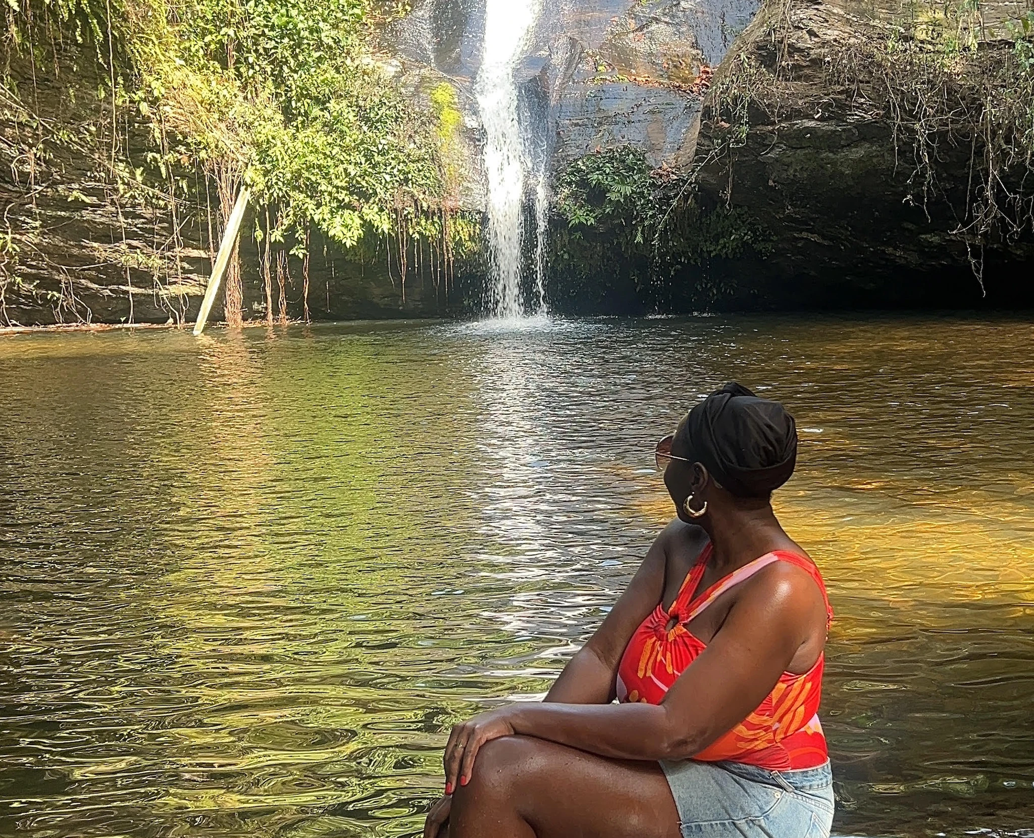 A woman sits and looks at a waterfall in Togo