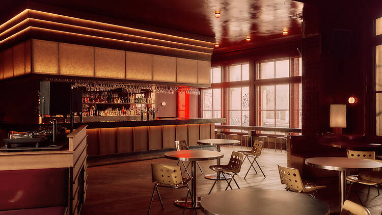 Tables and chairs in empty room in front of 1970s-esque bar