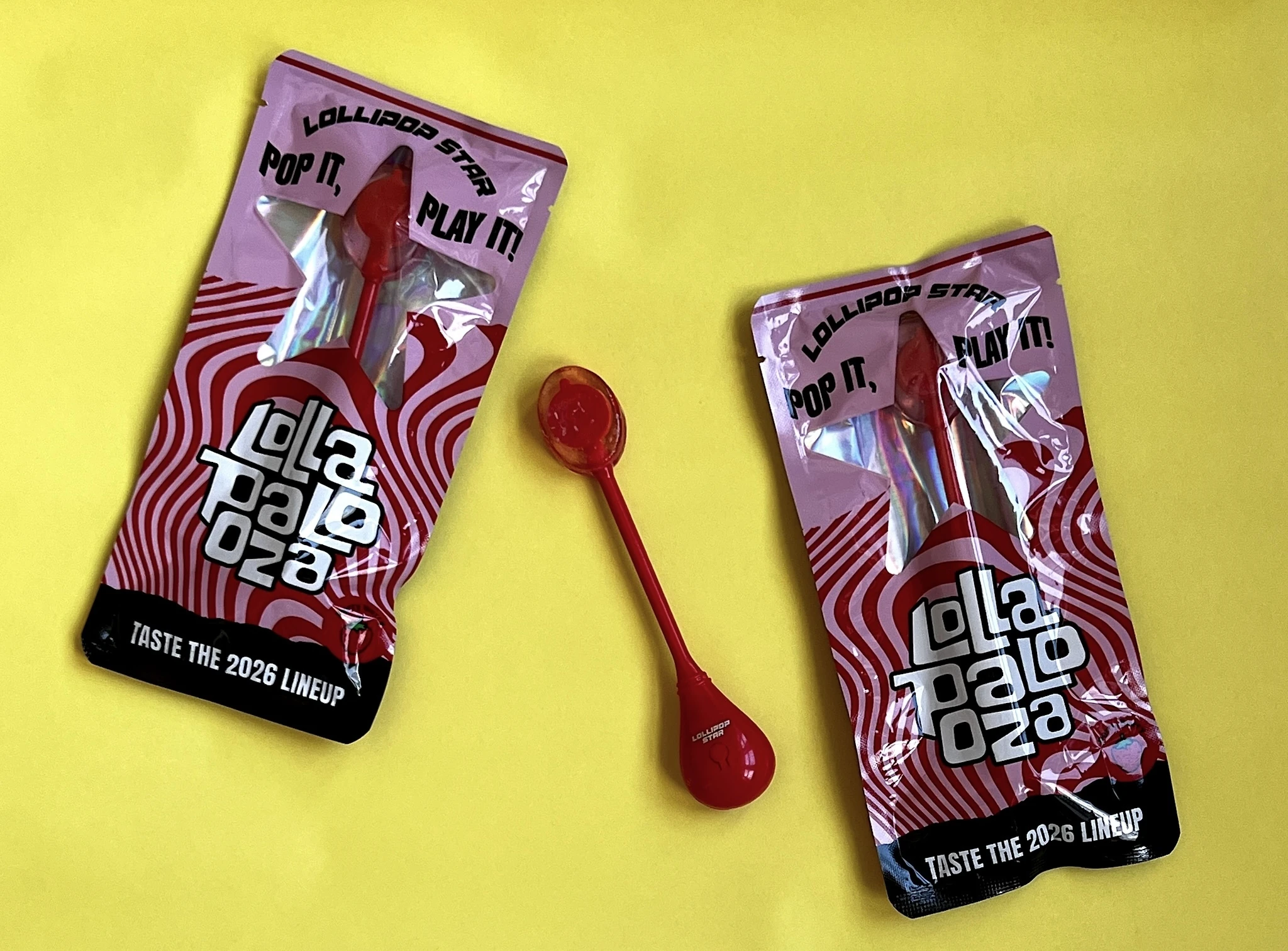 Lollapalooza-branded lollipops are arranged on a bright yellow backdrop.