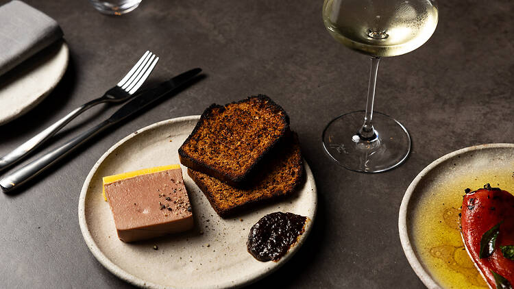 A plate of food and glass of white wine at Suze.