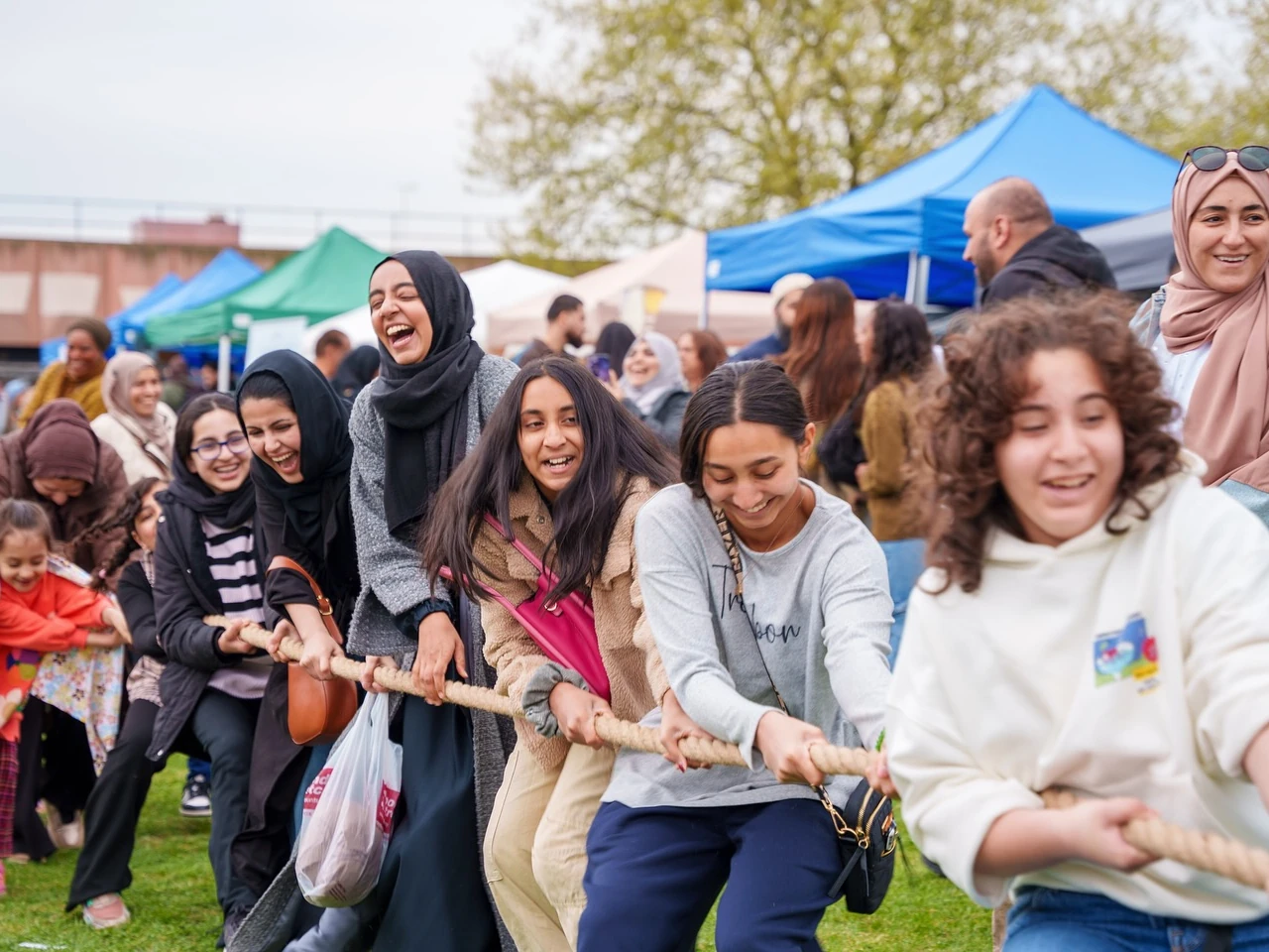 A group of women and girls play tug-of-war at London Eid Festival
