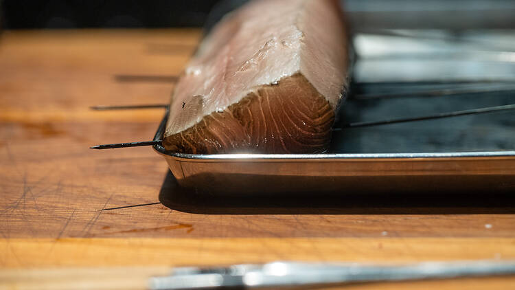 Savustetun kalasen pala metallitarjottimella ravintolassa Shii Helsingissä