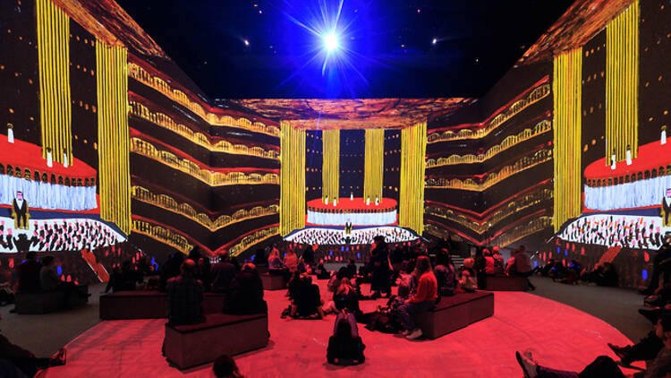 “David Hockney Bigger and Closer (not smaller and further away)” at Lightroom King’s Cross, London, featuring “Raised Stage with Masks, Narrator and Auditorium” from “Oedipus Rex,” 1981.