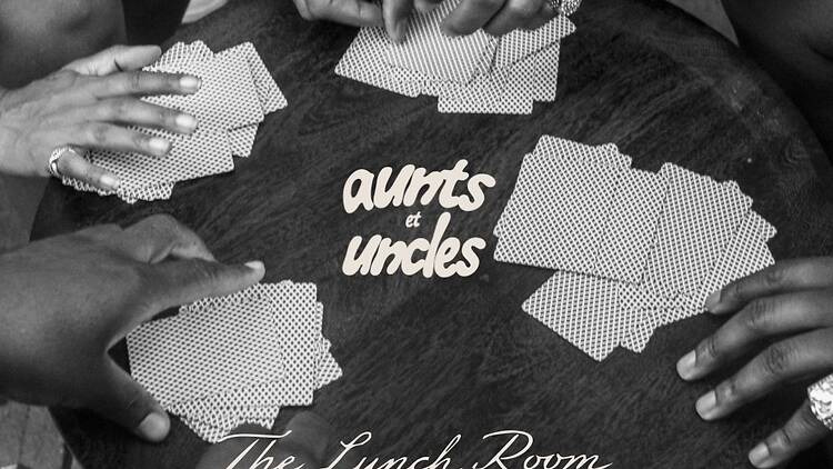 A round table with card games and hands playing spades