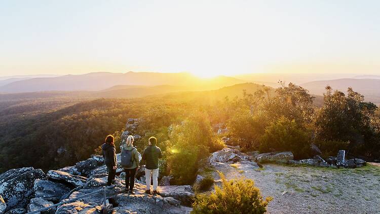 Hikers on the Grampians Peaks Trail at sunset.