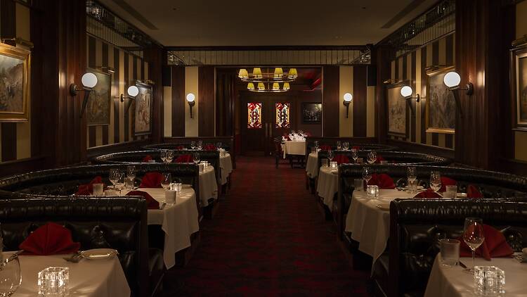 A hallway with black booths and wood paneling