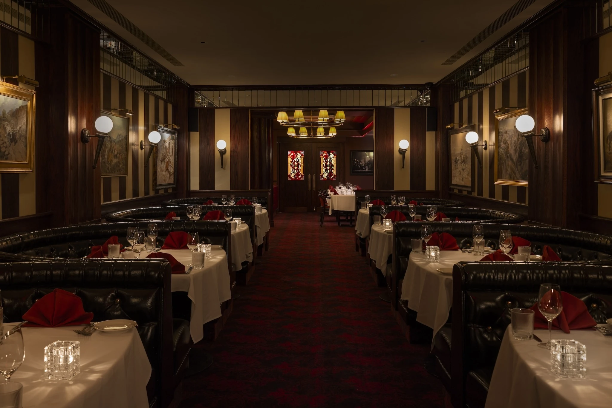 A hallway with black booths and wood paneling