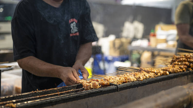 Vendor grilling skewers at Hawker 88 Night Market - Queen Vic Market