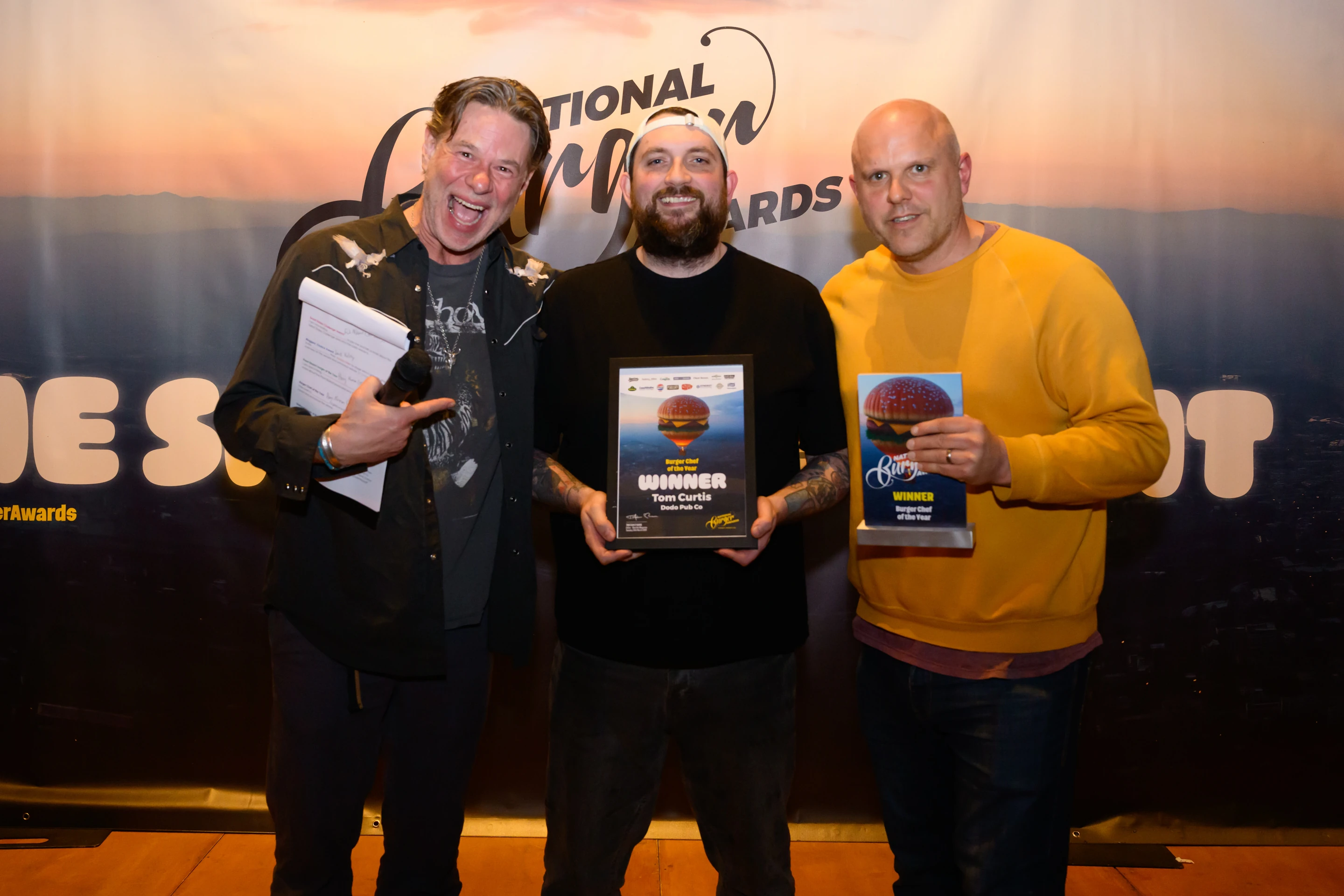 Three men hold prize for best burger chef of the year