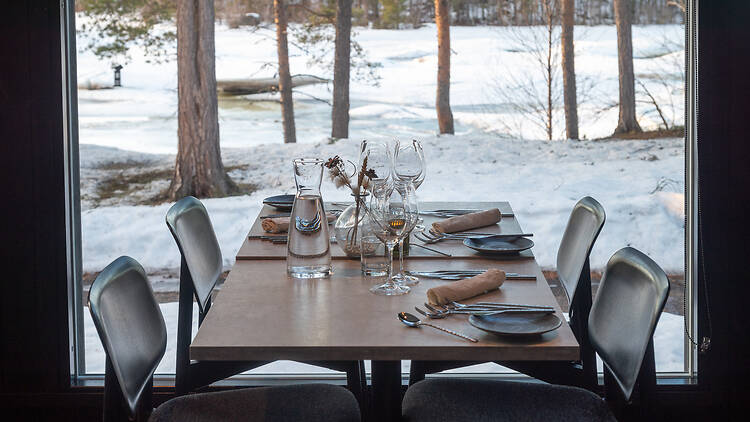 Pöytä ravinolassa Aanaar, ikkunasta näkyy talvinen maisema