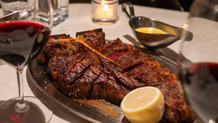 Big T-bone steak on a metal plate in The Grand Bar & Grill restaurant in Helsinki